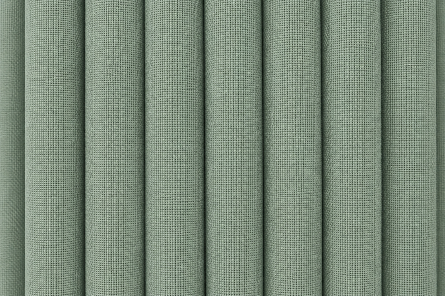 A close-up of vertically pleated fabric in a muted sage green color, showing the woven texture and soft shadows between the folds.