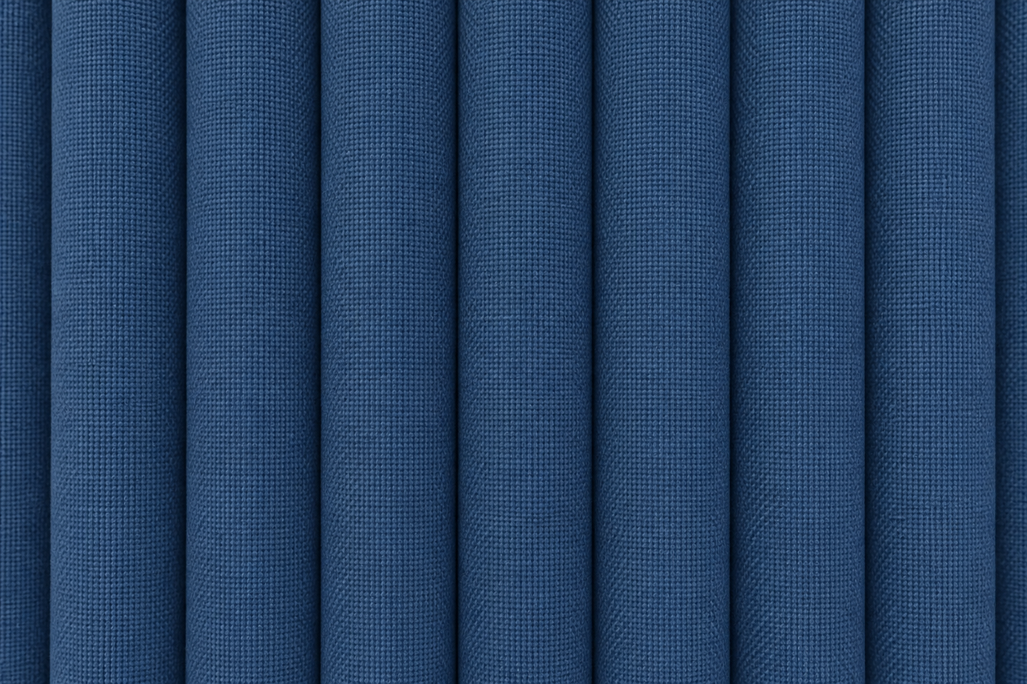 A close-up of blue textured fabric with vertical pleats or folds filling the frame.