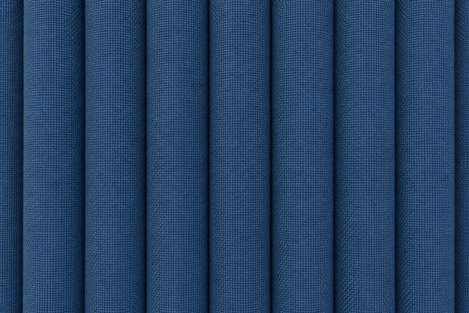 A close-up of blue textured fabric with vertical pleats or folds filling the frame.