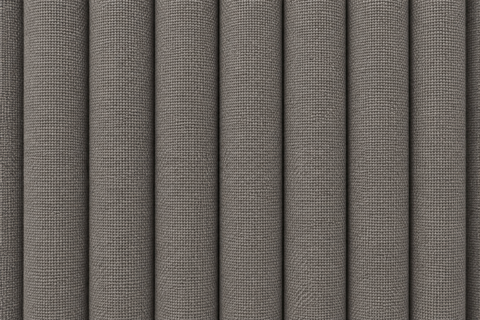 A close-up of vertically pleated fabric or upholstery material in a medium warm gray color, showing a fine woven texture.