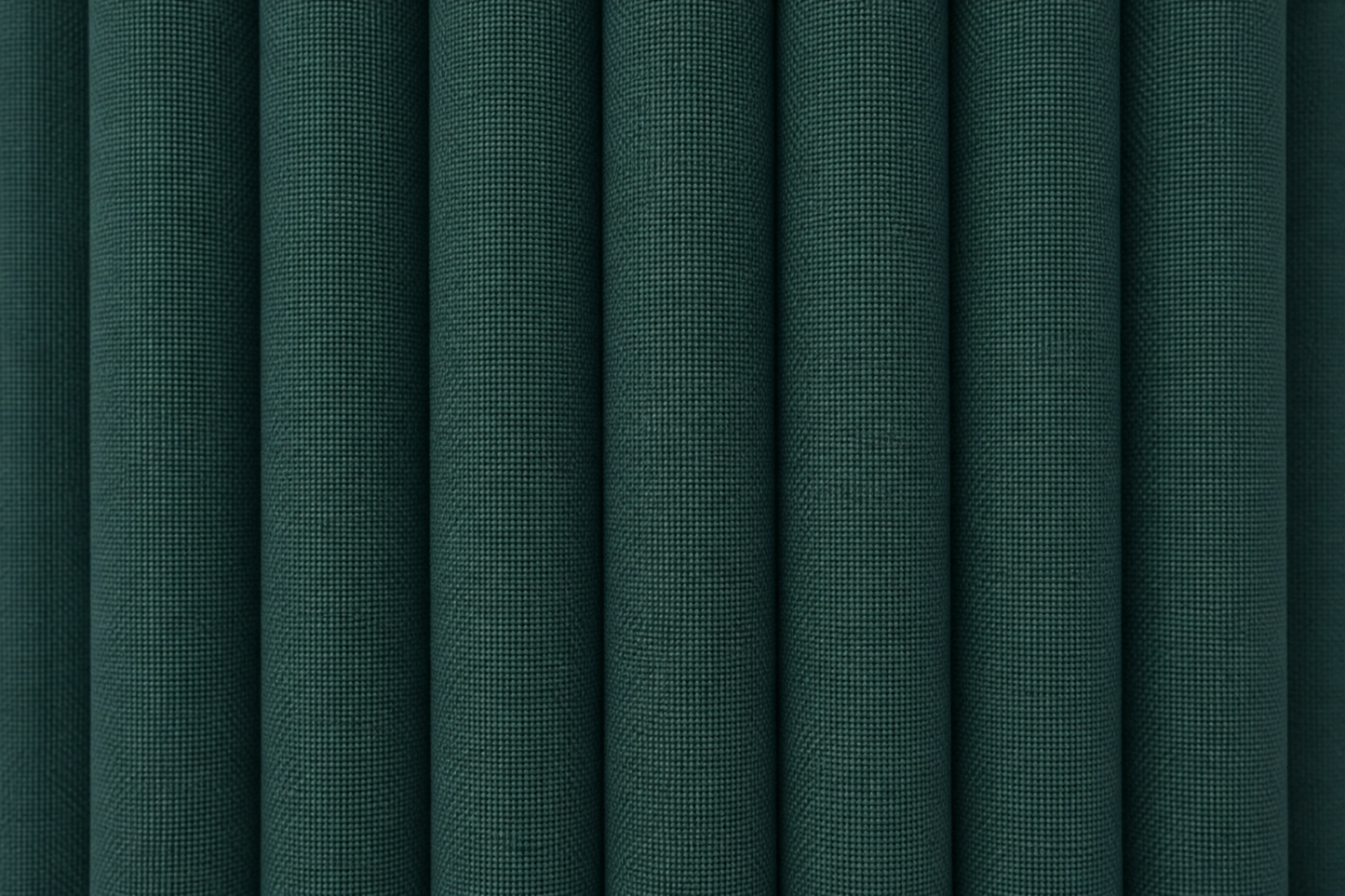 Dark green textured fabric with vertical pleats or folds filling the frame.